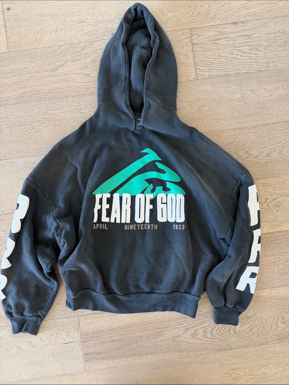 Fear of God Black Hoodie with Teal Chest Graphic and White Sleeve Logos